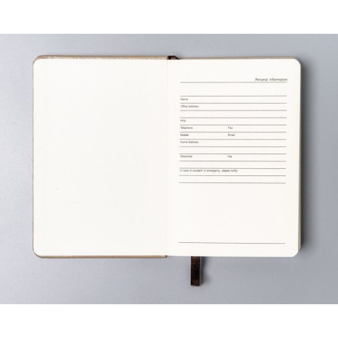 Beżowy notes w formacie A6 zadrukowany w kropki, wyposażony w gumkę zamykającą - Peterson